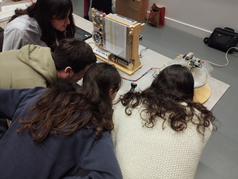 Des élèves ont perforé une feuille afin que la machine exécute un programme et ils l’observent en action.